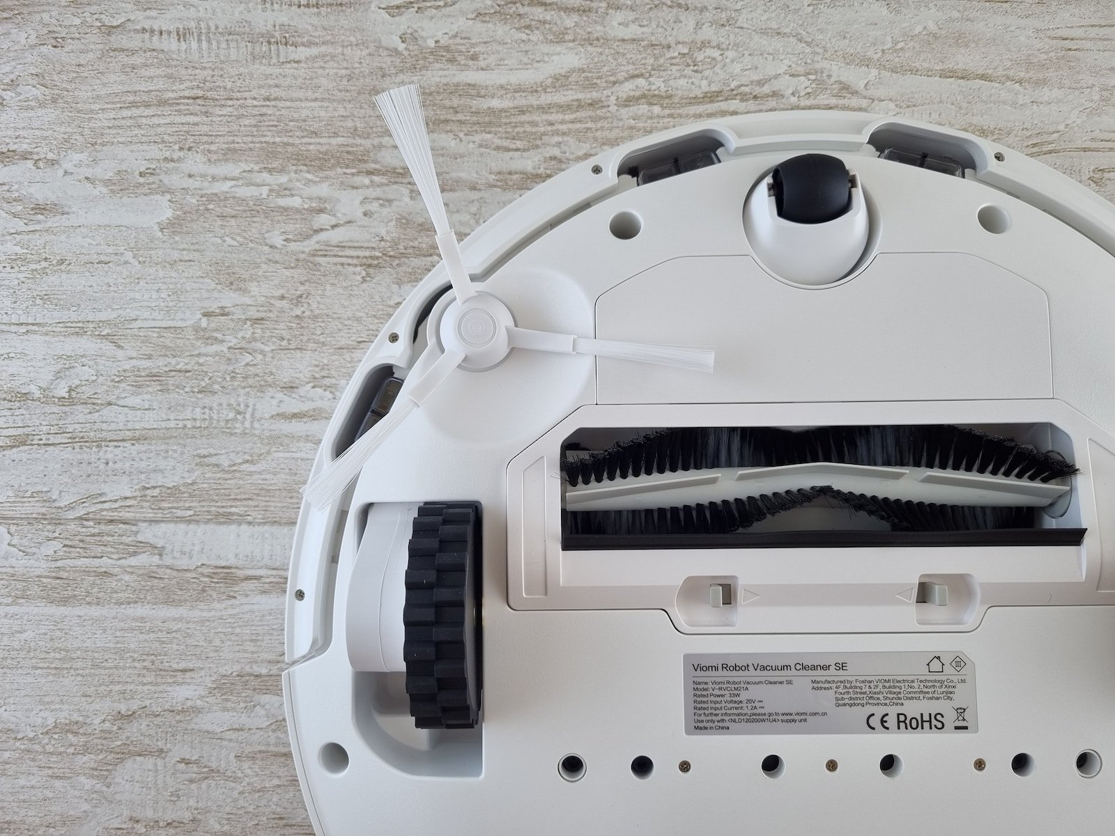 a white robot vacuum sitting on top of a wooden floor
